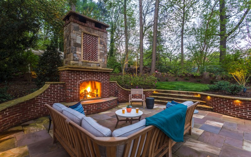 Cozy backyard fireplace setting at dusk.